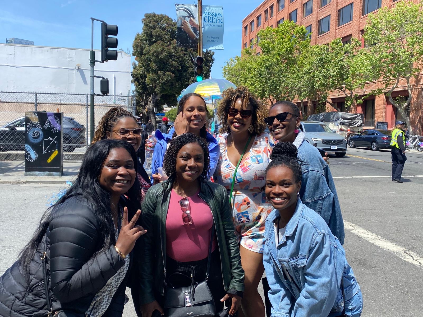 A joyful group gathered on a sunny SF street in the Mission Creek neighborhood